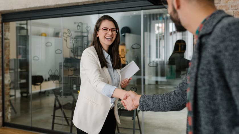 Career program student in suit shaking hands with a professional