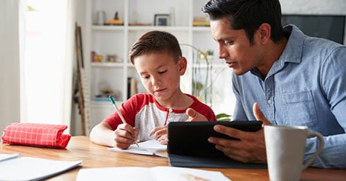 A parent and child researching online school vs traditional education.