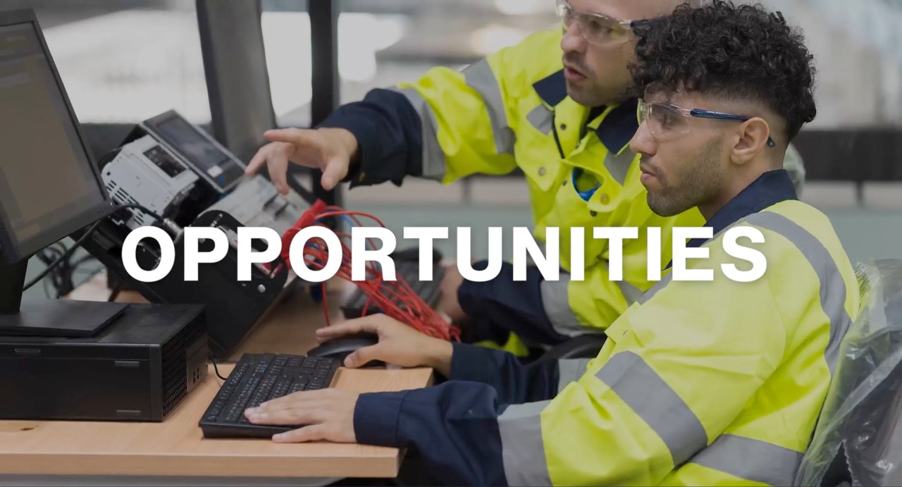 A skilled professional working on a computer with a colleague