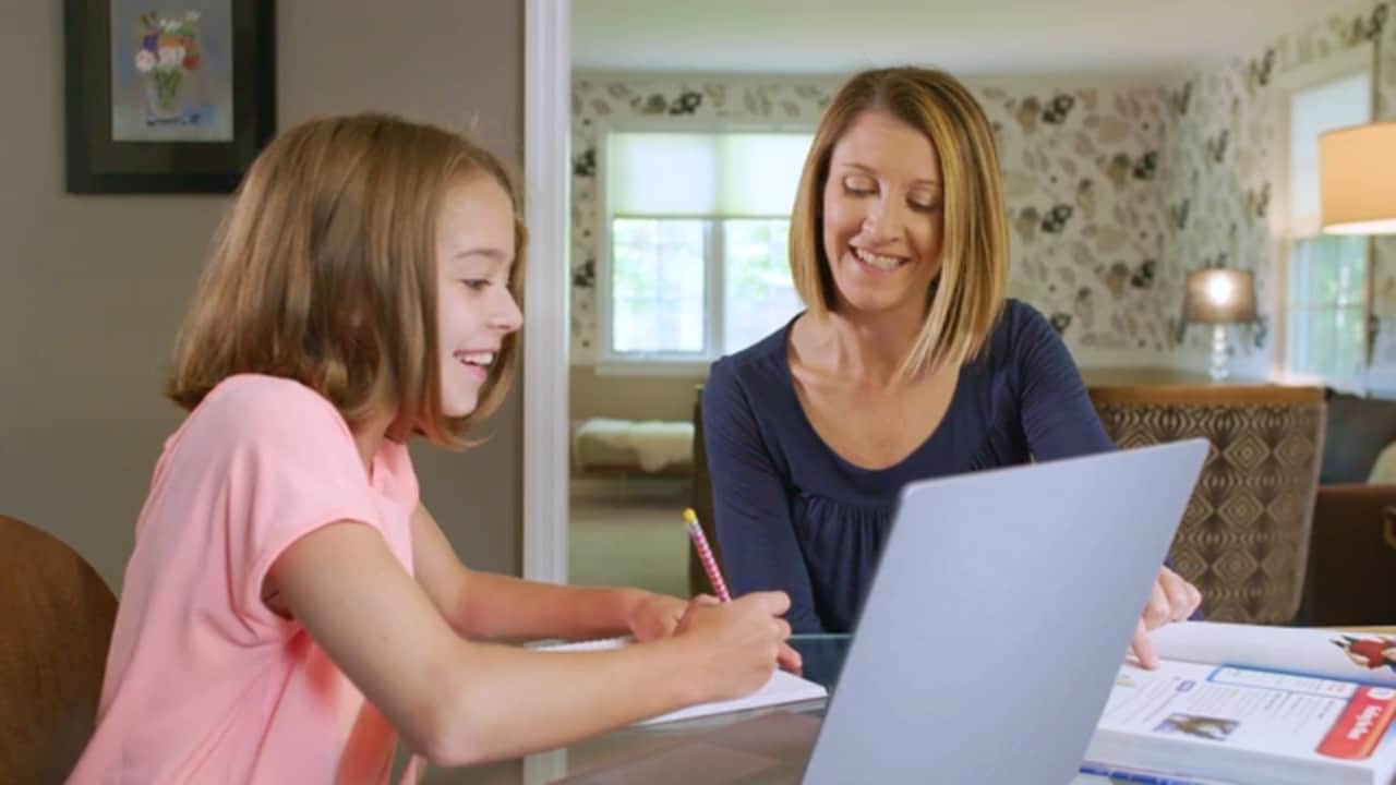 A learning coach helping her daughter study online.
